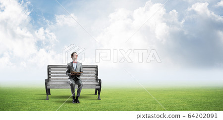 Young businessman or student studying the science in summer park Young businessman or student studying the science in summer park 64202091