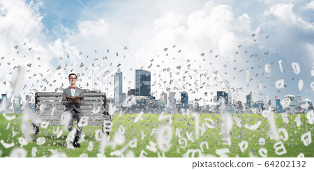 Young businessman or student studying the science and symbols fly around Young businessman or student studying the science and symbols fly around 64202132