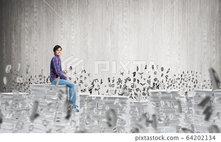 Attractive man sitting on pile of paper documents. Attractive man sitting on pile of paper documents. 64202134