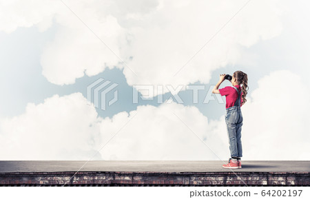 Concept of careless happy childhood with girl of school age look 64202197