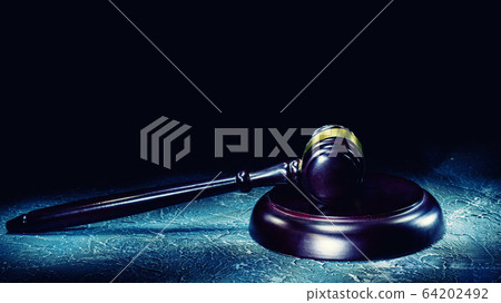 Judge's gavel lies on a stone table. Judge's gavel lies on a stone table. 64202492