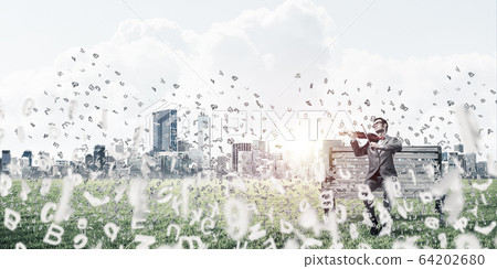 Handsome violinist in park on wooden bench and symbols fly aroun Handsome violinist in park on wooden bench and symbols fly aroun 64202680