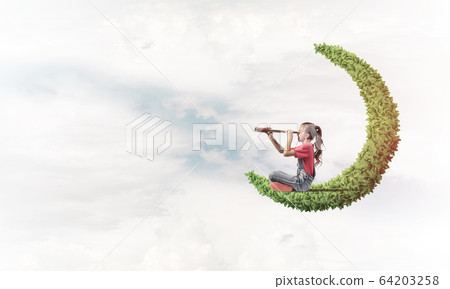 Concept of careless happy childhood with girl on green moon Concept of careless happy childhood with girl on green moon 64203258