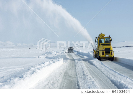 Snow plough removes fresh snow from the road Snow plough removes fresh snow from the road 64203464