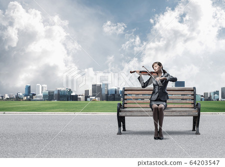 Young woman with violin sitting on wooden bench Young woman with violin sitting on wooden bench 64203547