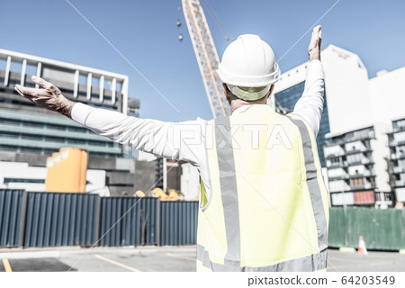 Senior foreman in glasses doing his job at building area on sunn Senior foreman in glasses doing his job at building area on sunn 64203549