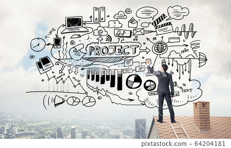 Rear view of businessman on house roof drawing his new business Rear view of businessman on house roof drawing his new business 64204181
