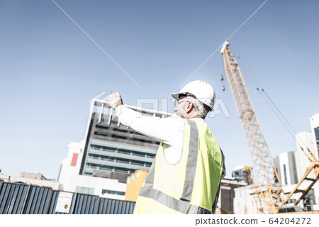 Senior foreman in glasses doing his job at building area on sunn Senior foreman in glasses doing his job at building area on sunn 64204272