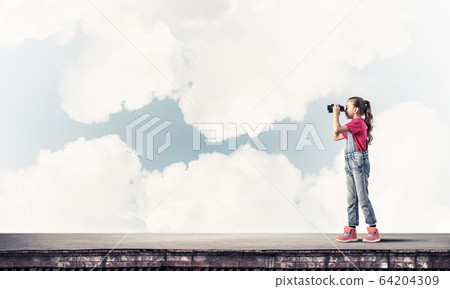 Concept of careless happy childhood with girl of school age look 64204309