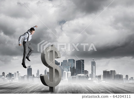 Determined banker man against modern cityscape breaking dollar concrete figure Determined banker man against modern cityscape breaking dollar concrete figure 64204311