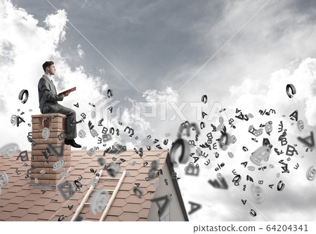 Man on brick roof reading book and symbols flying around 64204341