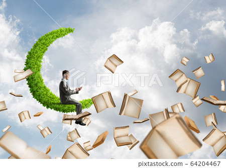 Man using smartphone and many books flying in air Man using smartphone and many books flying in air 64204467