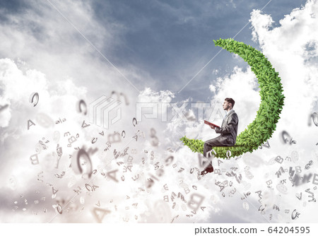 Man or student sitting on green moon and reading book 64204595
