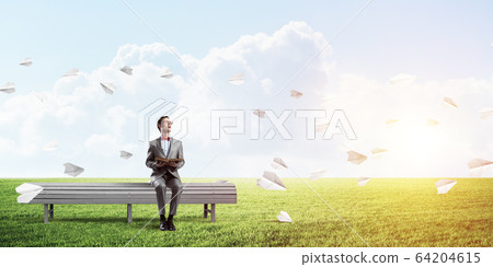 Young businessman or student studying the science and paper planes fly around Young businessman or student studying the science and paper planes fly around 64204615