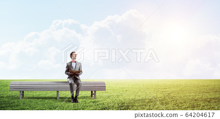 Young businessman or student studying the science in summer park Young businessman or student studying the science in summer park 64204617
