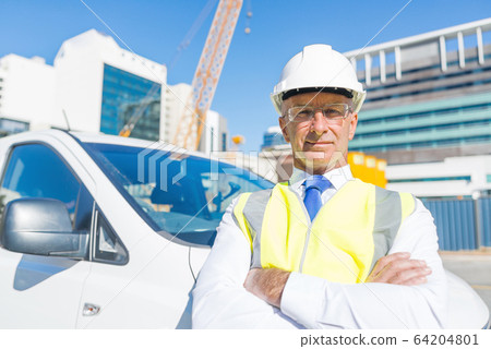 Senior builder man outdoors at construction site near his car looking in camera Senior builder man outdoors at construction site near his car looking in camera 64204801