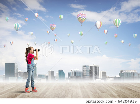 Concept of careless happy childhood with girl looking in binoculars 64204919