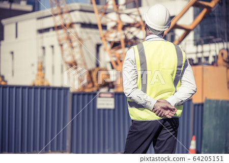 Senior foreman in glasses doing his job at building area on sunn Senior foreman in glasses doing his job at building area on sunn 64205151