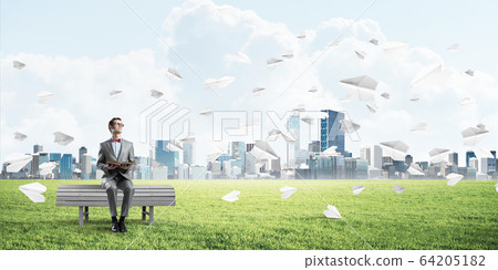Young businessman or student studying the science and paper planes flying around Young businessman or student studying the science and paper planes flying around 64205182
