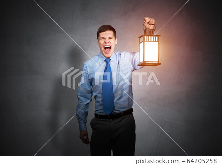 Screaming businessman holding glowing lantern Screaming businessman holding glowing lantern 64205258