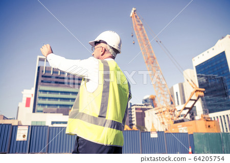 Senior foreman in glasses doing his job at building area on sunn Senior foreman in glasses doing his job at building area on sunn 64205754