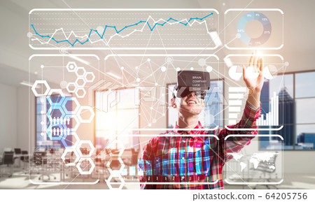 Young man in modern office interior experiencing virtual reality technology 64205756