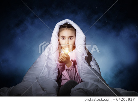 Frightened girl with flashlight under blanket 64205937