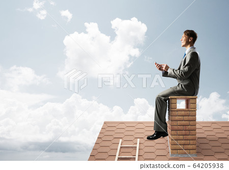 Businessman or student on brick roof smiling and making calls Businessman or student on brick roof smiling and making calls 64205938