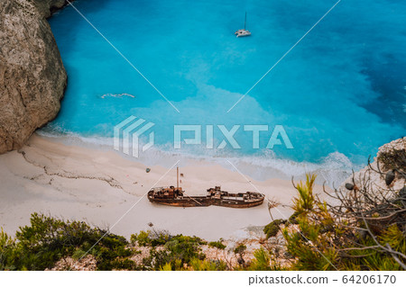 Shipwreck on Navagio beach. Azure turquoise sea water and paradise sandy beach in evening light. Famous tourist visiting landmark on Zakynthos island, Greece Shipwreck on Navagio beach. Azure turquoise sea water and paradise sandy beach in evening light. Famous tourist visiting landmark on Zakynthos island, Greece 64206170