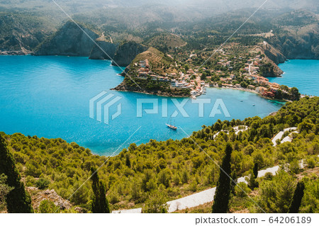 Top view to Assos village. Landmark place of Kefalonia island. Lonely white yacht at anchor in calm beautiful lagoon surrounded by pine and cypress trees. Greece Top view to Assos village. Landmark place of Kefalonia island. Lonely white yacht at anchor in calm beautiful lagoon surrounded by pine and cypress trees. Greece 64206189
