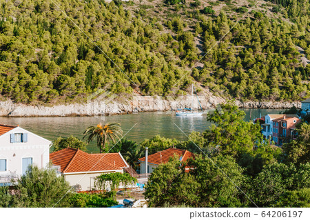White yacht in beautiful sea cove of Assos village at Kefalonia island. Greece White yacht in beautiful sea cove of Assos village at Kefalonia island. Greece 64206197