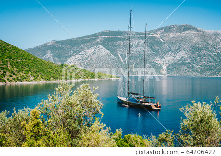Summer vacation in Greece. Luxury black private yacht at anchor in beautiful sea lagoon. Ithaka island 64206422
