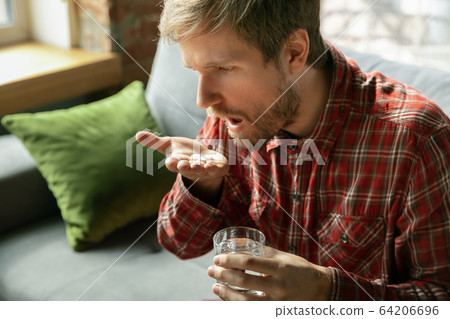 Caucasian man staying at home during quarantine because of coronavirus spreading 64206696