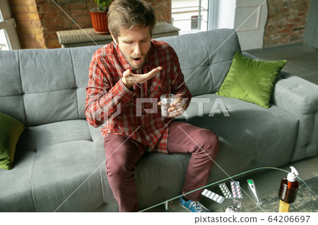 Caucasian man staying at home during quarantine because of coronavirus spreading 64206697