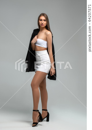 girl in white with a black jacket on a light background 64207871