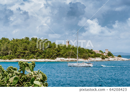 Summer holiday vacation. Kefalonia island, Greece. White sailing boat approaching port of Fiskardo 64208423