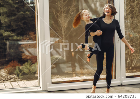Woman with daughter is engaged in gymnastics 64208733