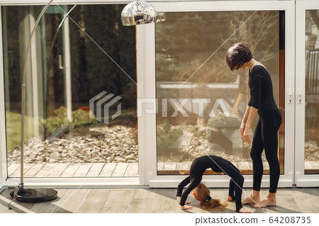 Woman with daughter is engaged in gymnastics 64208735