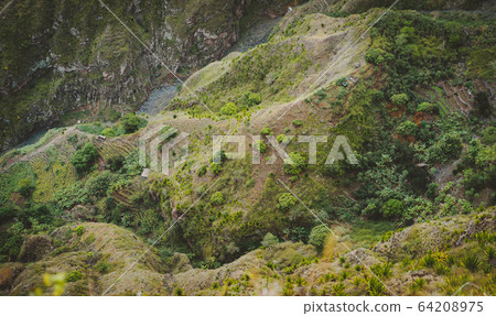Santo Antao, Cape Verde. Mountain ridge with dry river bed of canyon with steep cliff and winding riverbed with lush green vegetation Santo Antao, Cape Verde. Mountain ridge with dry river bed of canyon with steep cliff and winding riverbed with lush green vegetation 64208975