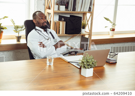 African-american doctor consulting for patient, working in cabinet, close up 64209410