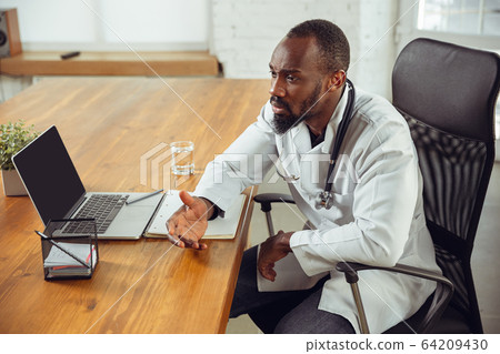 African-american doctor consulting for patient, working in cabinet, close up African-american doctor consulting for patient, working in cabinet, close up 64209430