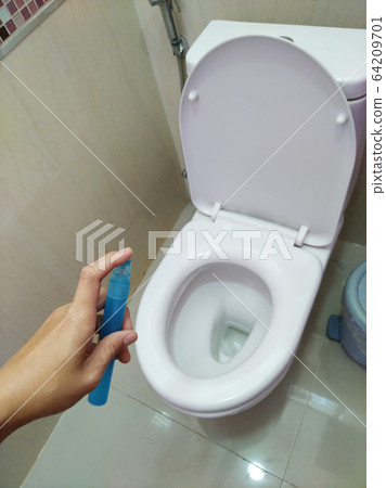 Men's hands use alcohol spray to flush the toilet to disinfect before use. Men's hands use alcohol spray to flush the toilet to disinfect before use. 64209701