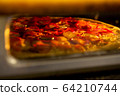 Pizza baked in an electric oven close-up 64210744