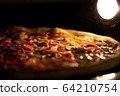 Pizza baked in an electric oven close-up 64210754