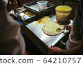 The chef is making pizza. spreads white sauce on 64210757