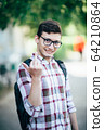 handsome young man smiling outdoors 64210864