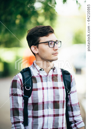 handsome young man smiling outdoors 64210865