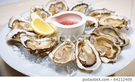 Fresh oysters on ice with lemon close up. Shallow dof. 64212409