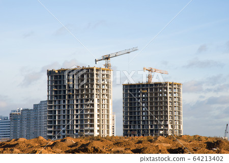 Tower cranes working at construction site against blue sky 64213402