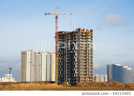 Tower cranes working at construction site against blue sky 64213403